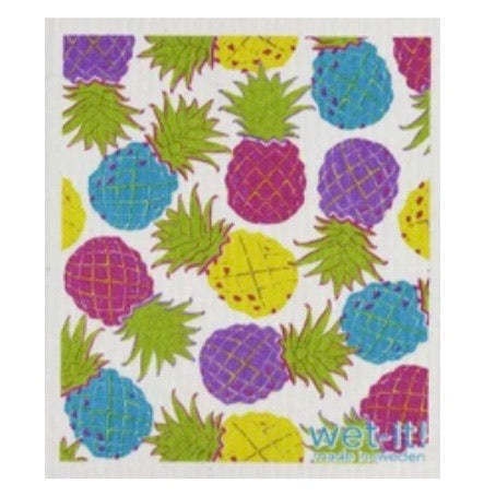 ivory colored rectangle shaped scrubbing pad with multiple scattered multi colored pineapples in bright yellow, purple, teal, and magenta screen printed all over it