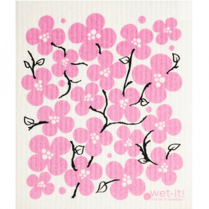 ivory colored rectangle shaped scrubbing pad with black branches and pink flower blossoms screen printed on it