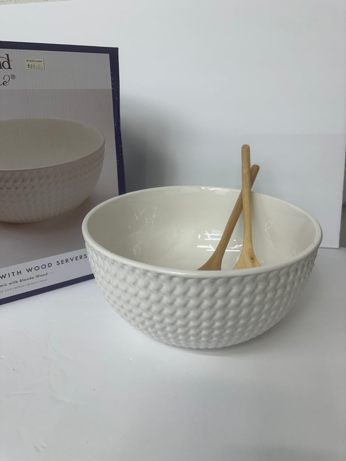 White salad bowl with wooden server utensils