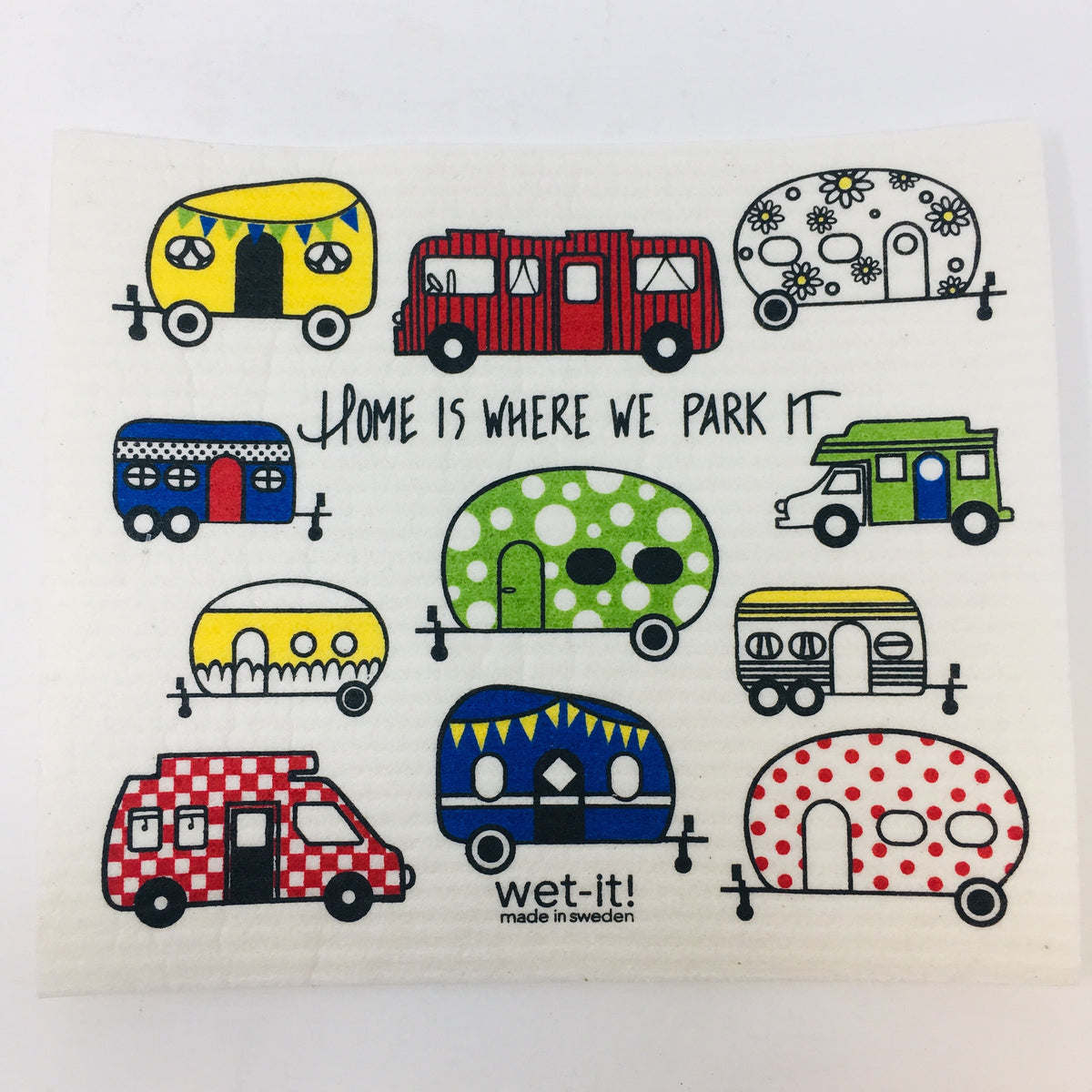 ivory colored rectangle shaped scrubbing pad with a variety of campers and RV&#39;s in bright colors and patterns printed all over it and the saying &quot;Home is where we park it&quot; written in black screen printed on it