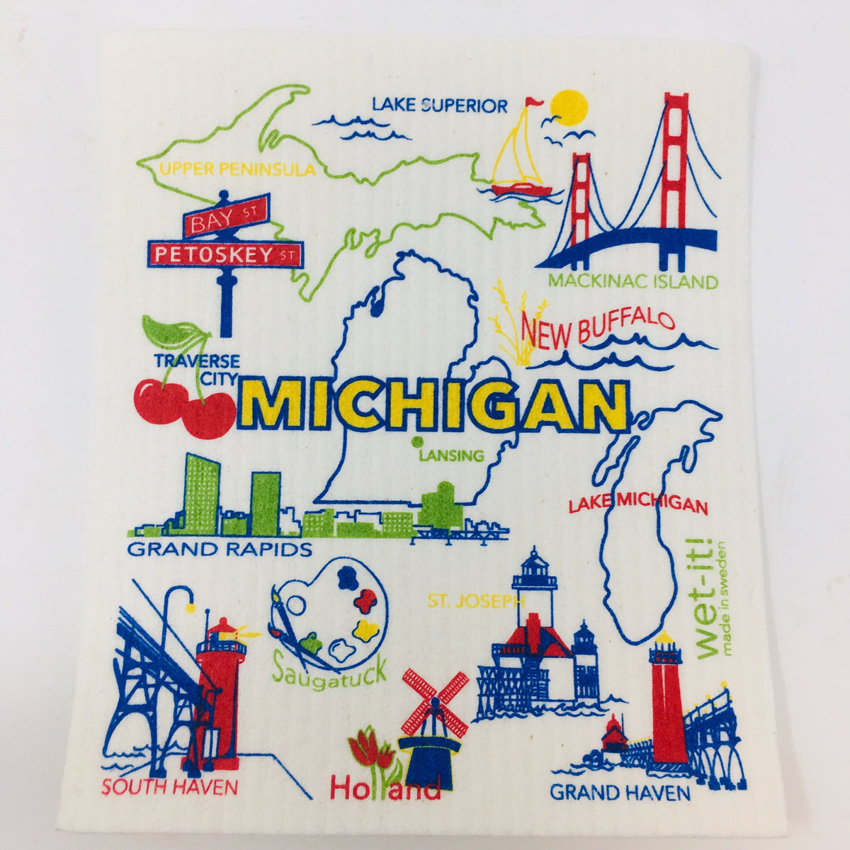 ivory colored rectangle shaped scrubbing pad with Michigan icons and scenes such as Mackinac Island and Bridge, Traverse City cherries, Holland Windmill, Grand Haven Lighthouse, Grand Rapids skyline in bright red, yellow, lime and blue colors screen printed on it