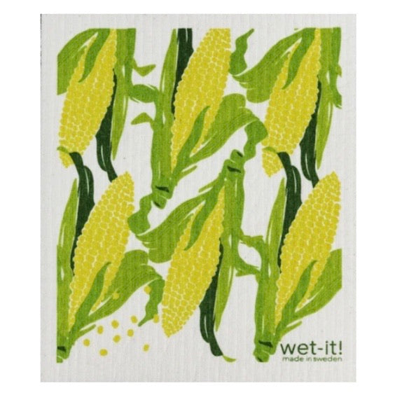 ivory colored rectangle shaped scrubbing pad with repeating ears of yellow corn on the cob in green husks screen printed on it